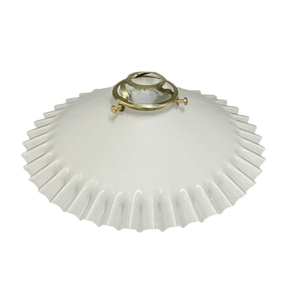 White pleated lampshade with a brass fitting on a white background