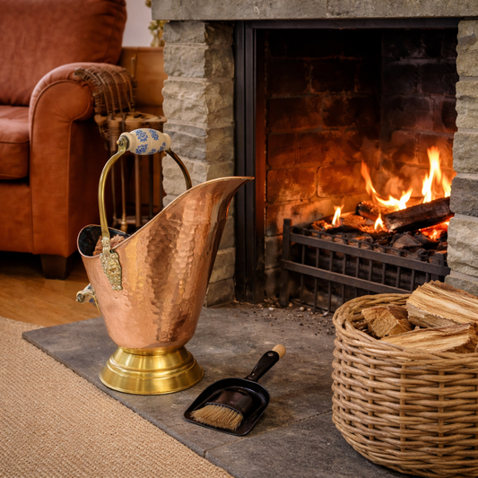 Copper ashes bucket and tool next to a fireplace with firewood basket.