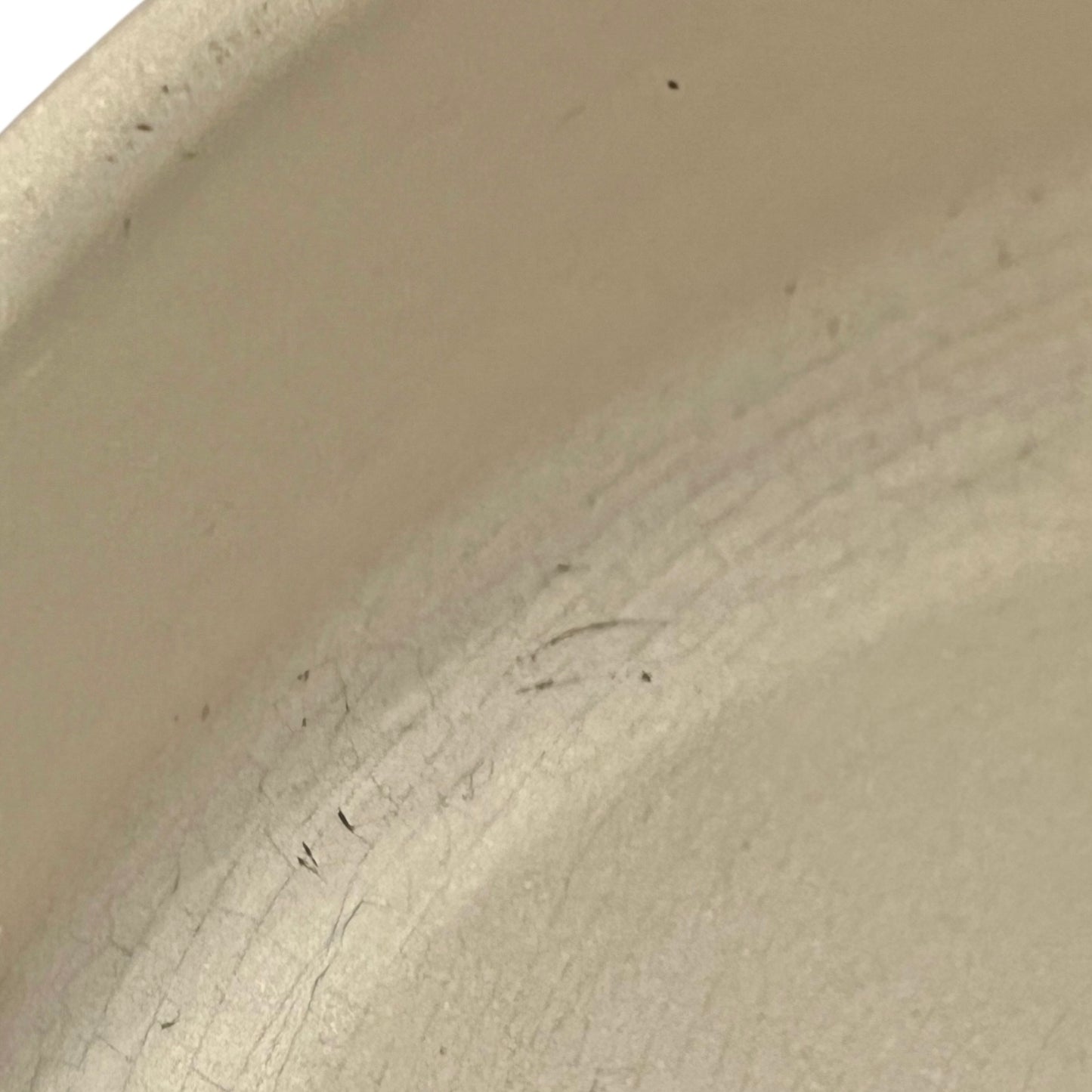 Close up of Le Creuset dish with beige interior on a white background