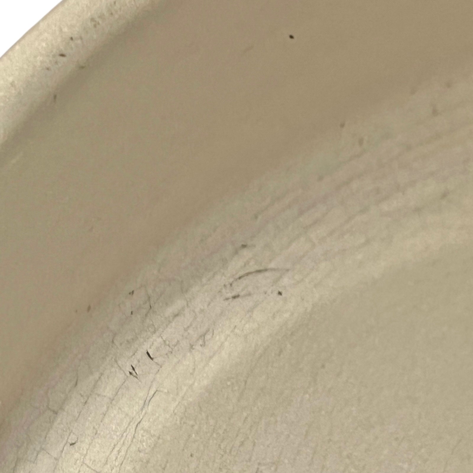 Close up of Le Creuset dish with beige interior on a white background