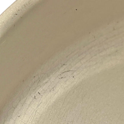 Close up of Le Creuset dish with beige interior on a white background