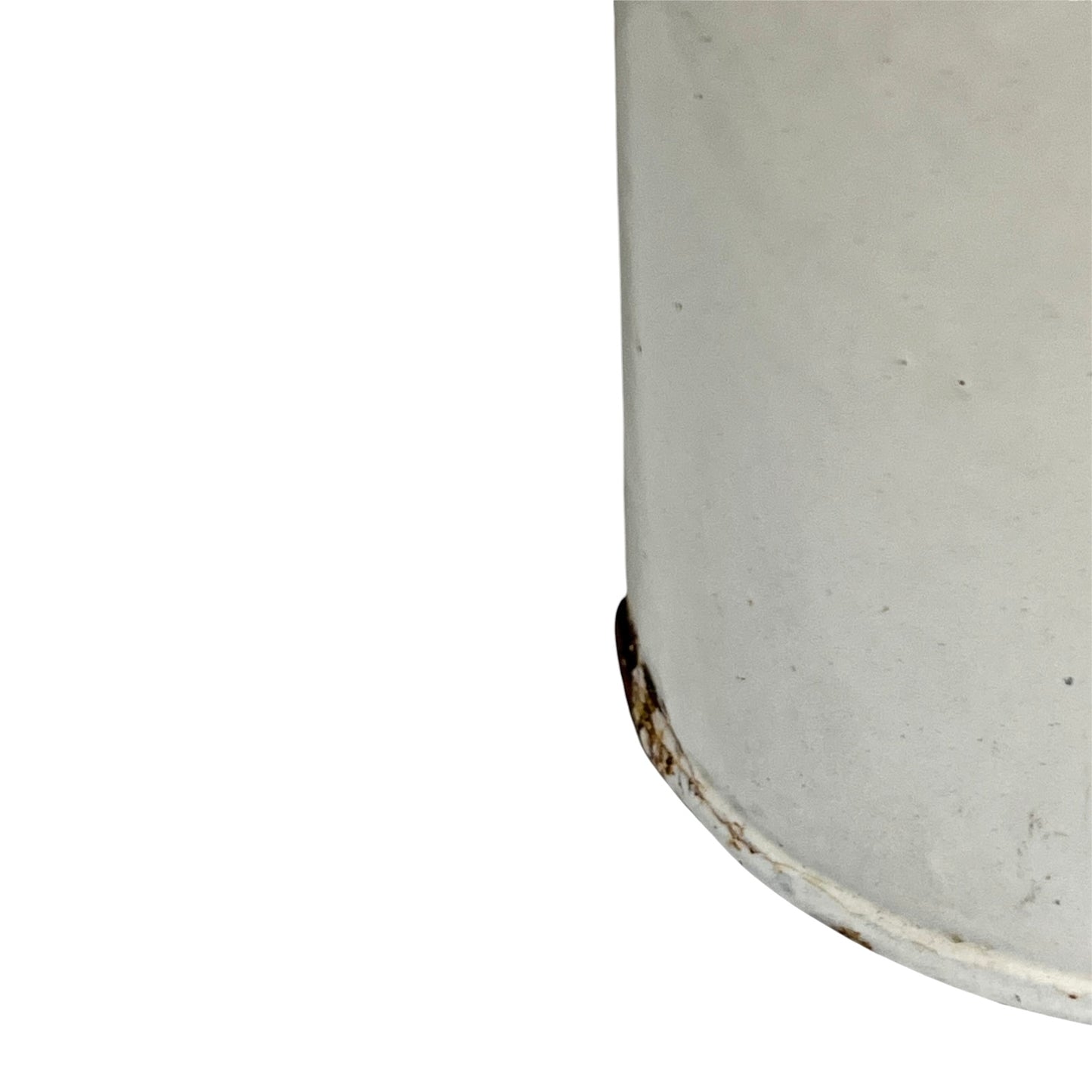 A close-up of the lower corner of a cylindrical white metal container or canister, showing a worn rusted base edge against a plain white background.