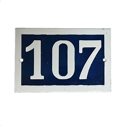 Navy blue rectangular plate with white numbers '107' on a white background