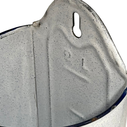 Close-up of an enamel planter with speckled glaze and blue rim on a white background