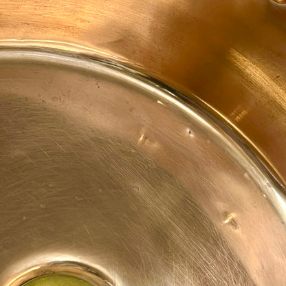 Close-up of a copper sink with a drain plug