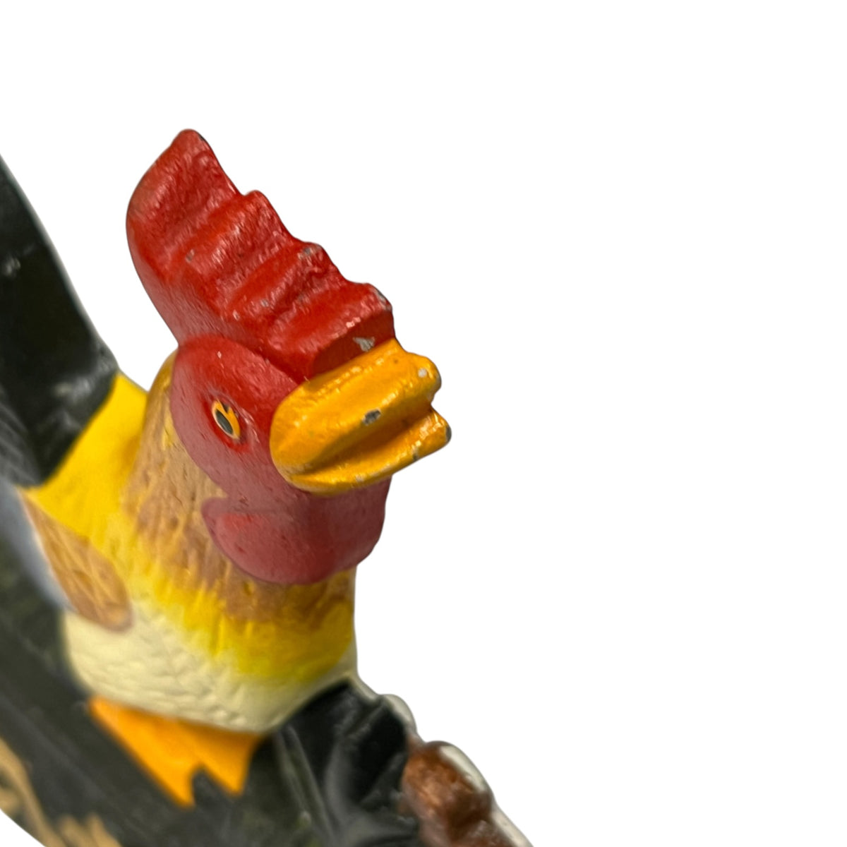 A close-up of a colorful rooster figurine on a black staff, shown against a plain white background.