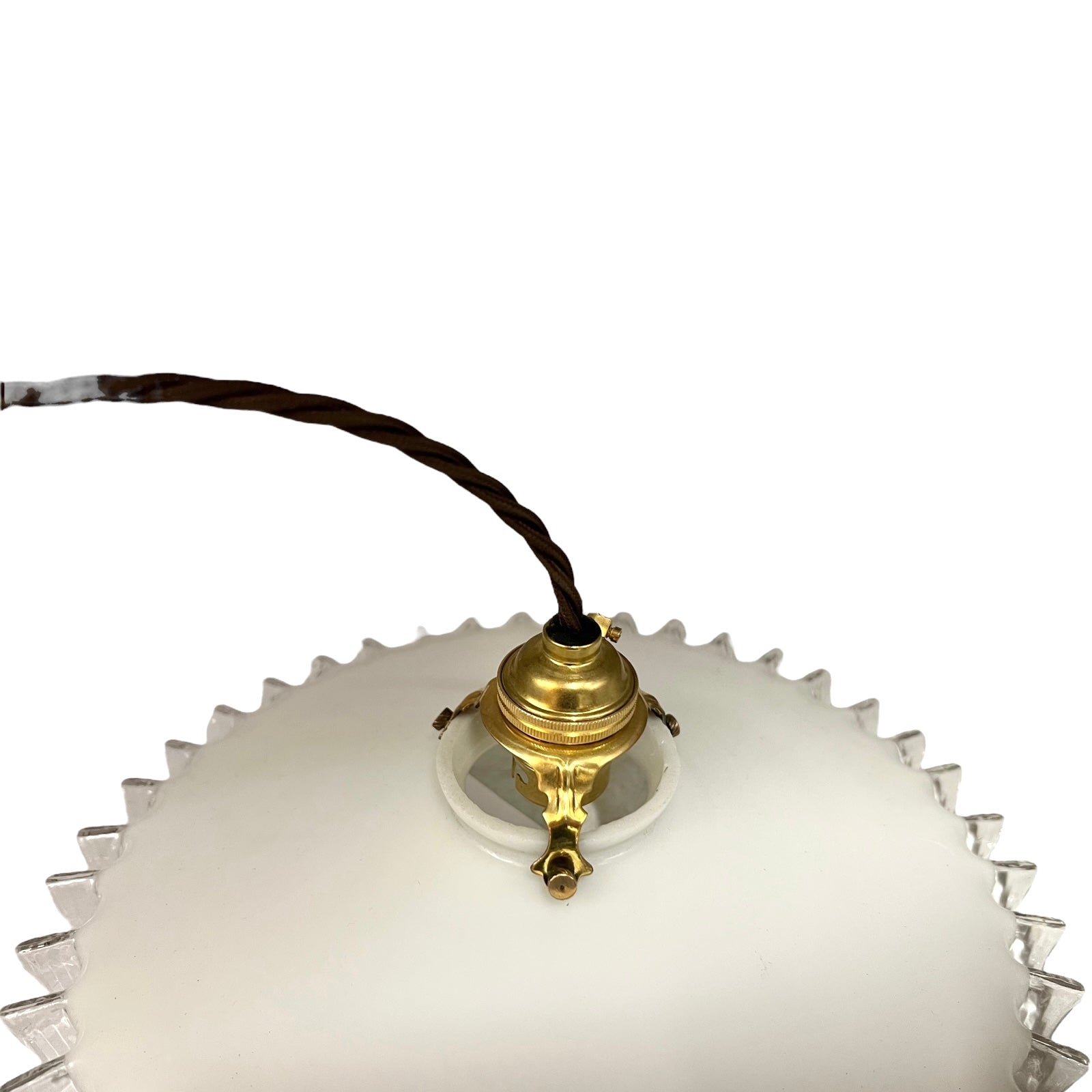 Close-up of a pendant light with white glass shade and brass fitting on a white background