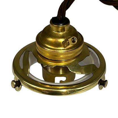 A polished brass ceiling light socket with a circular metal frame and a dark brown hanging cord, shown against a plain white background.