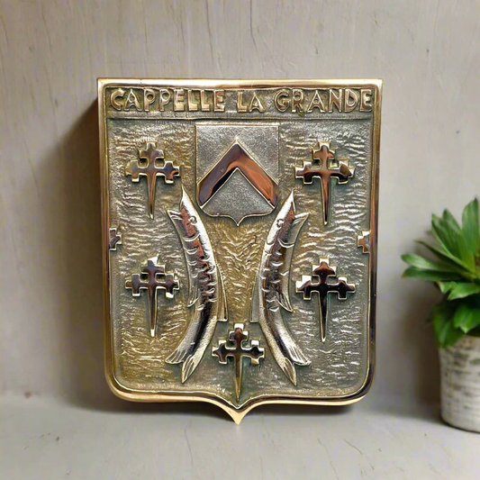 Decorative plaque with 'Cappelle la Grande' text and emblem on a neutral background