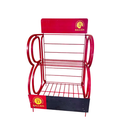 A red metal retail display rack with two tiers of wire shelving, featuring circular side supports and branded panels at the top and bottom that read BAGUEPI.
