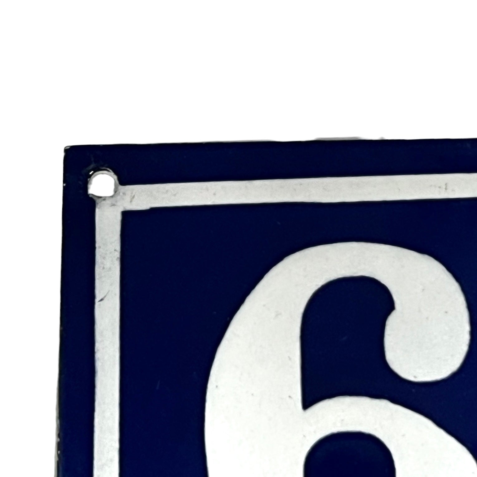 Close-up of a blue sign with a white number '6' on a white background