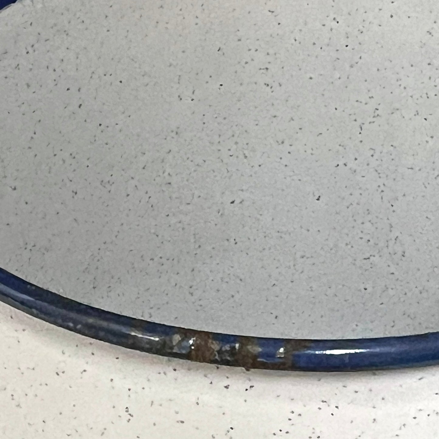 Close-up of a enamel planter with speckled pattern on a white background