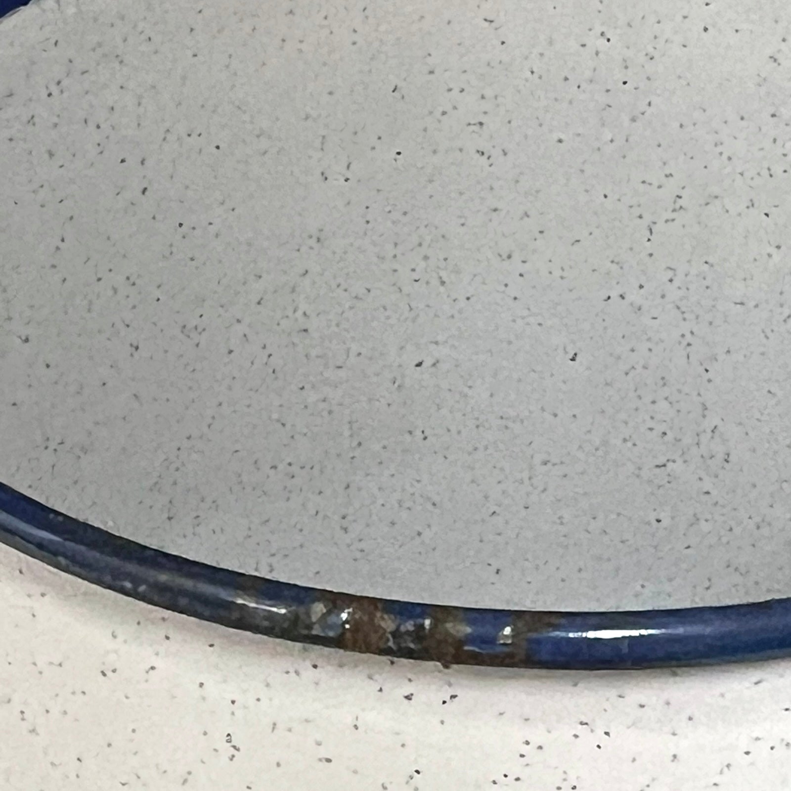 Close-up of a enamel planter with speckled pattern on a white background