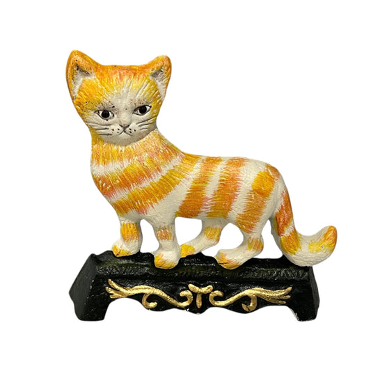 Cast iron cat doorstop with orange and white stripes on a decorative stand against a white background