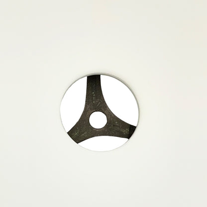 Round metallic object with a central hole on a light gray background