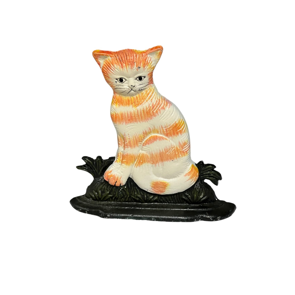 A vintage-style ceramic cat figurine with orange and white stripes, sitting on a dark green leafy base against a plain white background.