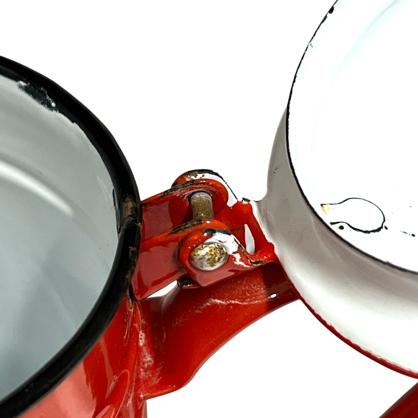 Close up of a red vintage French enamelled coffee pot on a white background