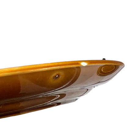 Close-up of a brown plate with a reflective surface on a white background