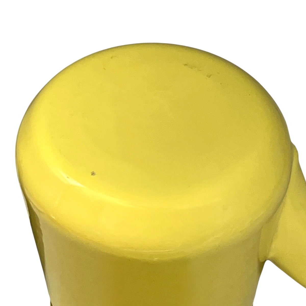 A close-up of a bright yellow teapot base, showing the top circular lid and a small side handle against a plain white background.