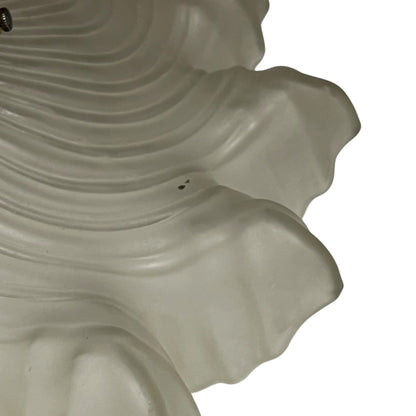 Close up of a vintage-style light fixture with frosted glass shade on a white background