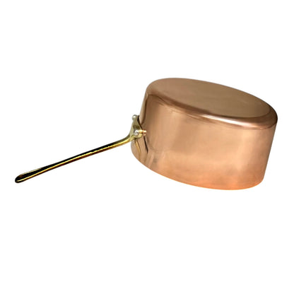 A copper saucepan with a long metal handle, shown on a plain white background.