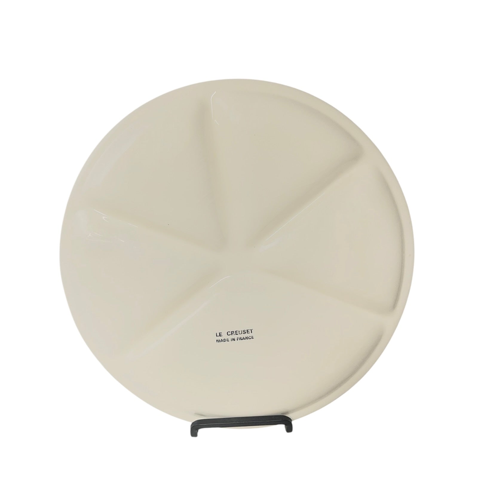 Round beige plate with a Le Creuset stamp on a white background