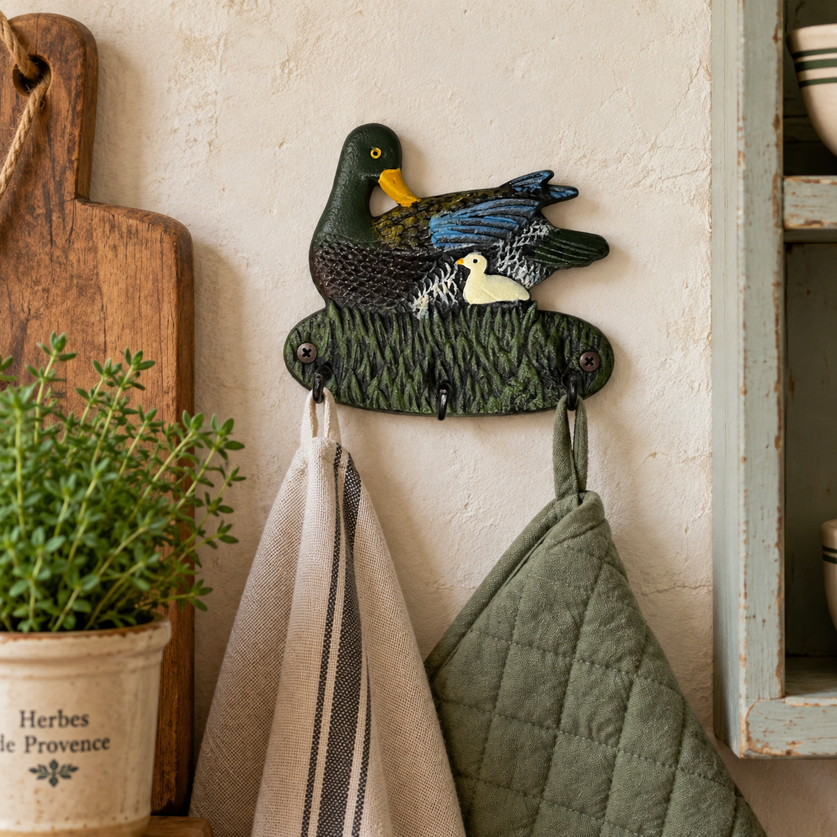 Small cast iron duck hook on a rustic kitchen wall