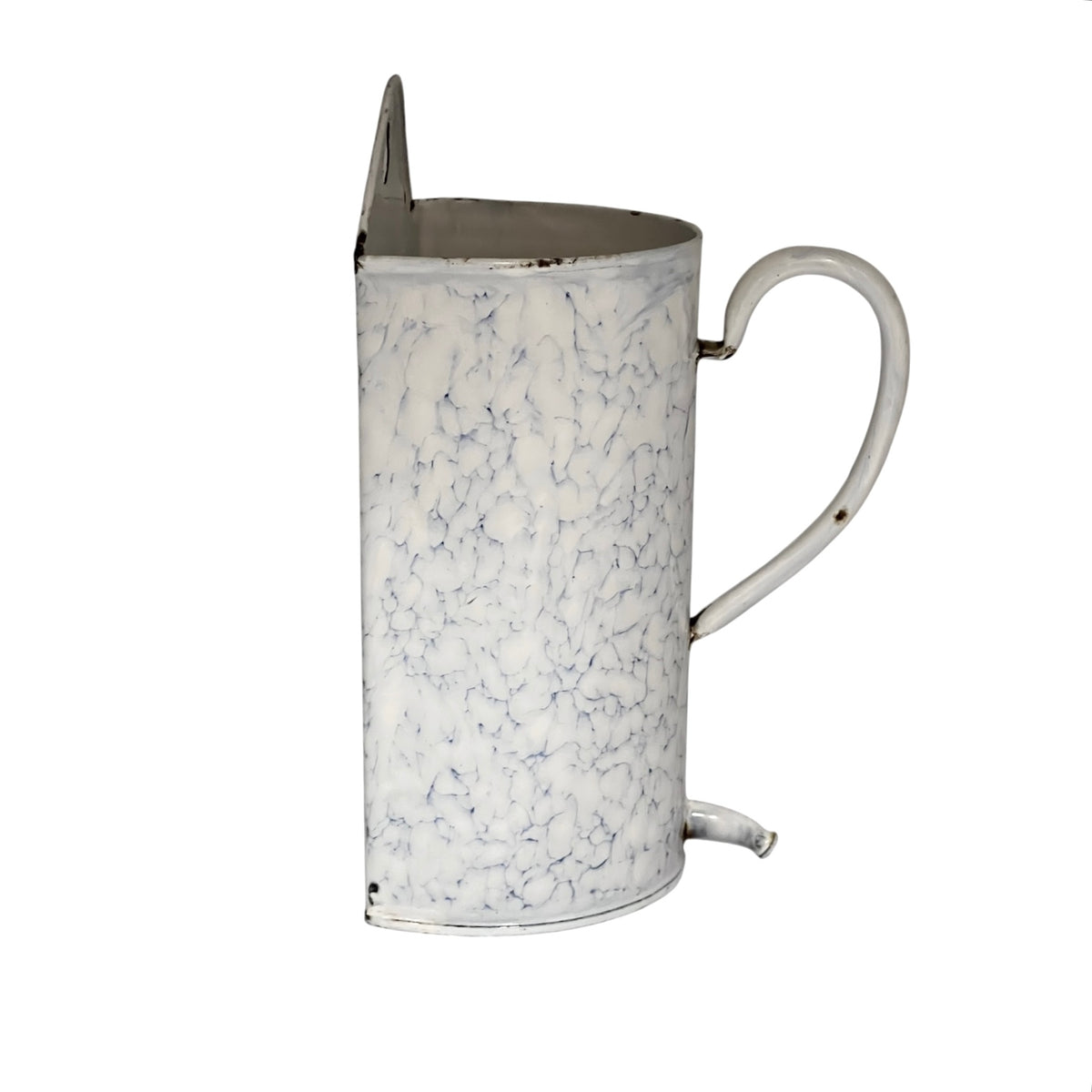 Side view of a  vintage-style white enamel planter with a blue crackle pattern, a metal top loop, a side handle, and a small spout, shown on a plain white background.