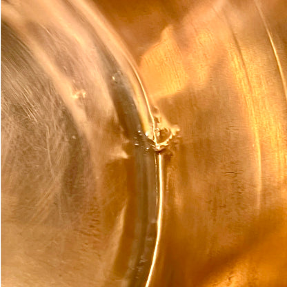 Close-up of a copper sink with a drain plug