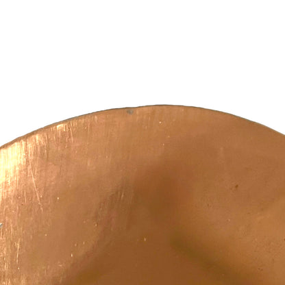 Close-up of a copper pan lid on a white background