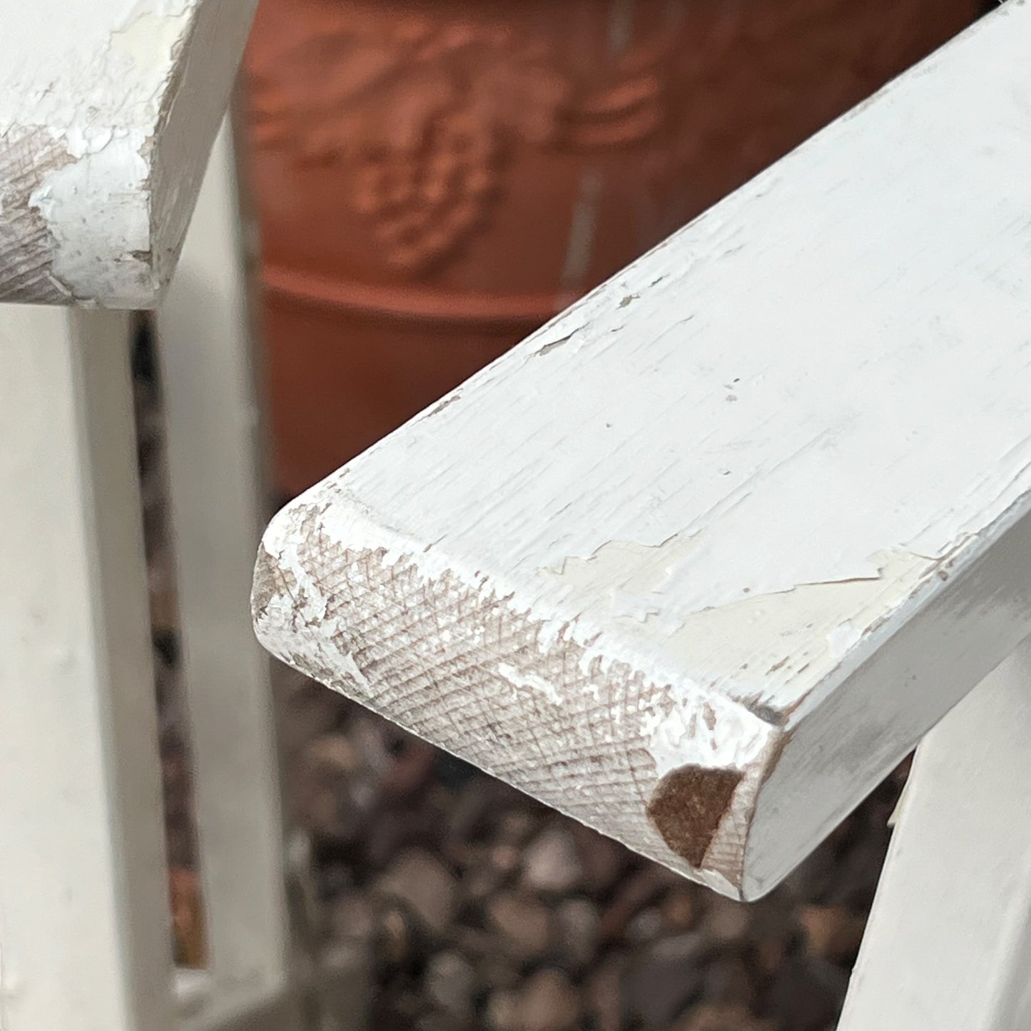 Close-up detail of French wooden slatted chairs, highlighting their condition in an outdoor setting.