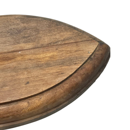 Close-up of a deer hoof on a wooden surface with a white background