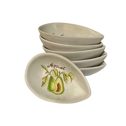 A stack of 6 oval ceramic bowls with one bowl in front, decorated with an avocado illustration and the word 'Avocat' on a white background.