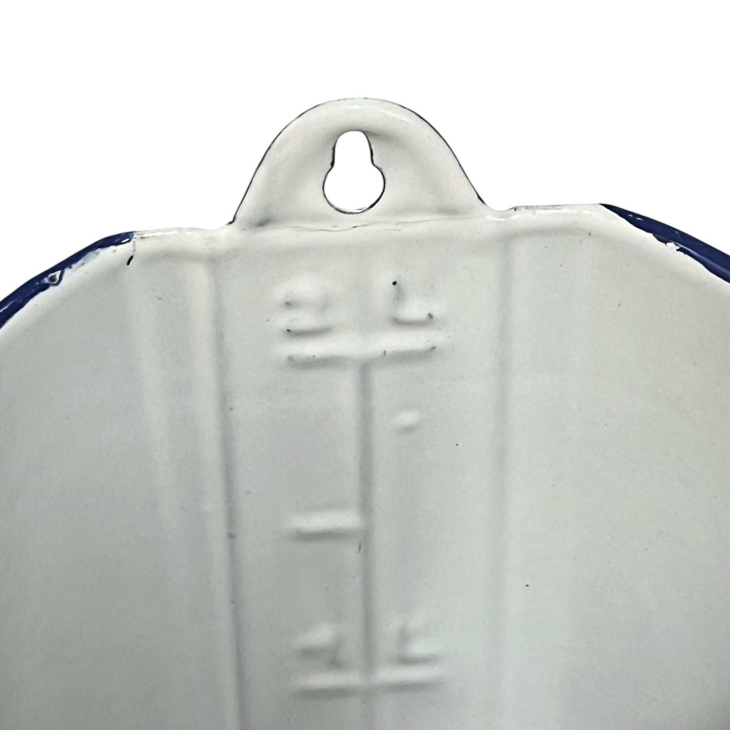 Close-up of the inside of a white enamel plant pot showing a 2 litre measurement with a blue rim on a plain white background.