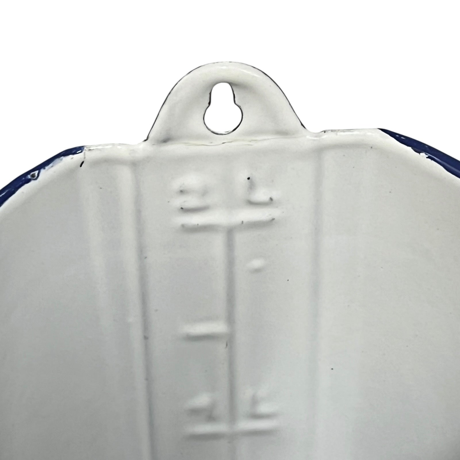 Close-up of the inside of a white enamel plant pot showing a 2 litre measurement with a blue rim on a plain white background.
