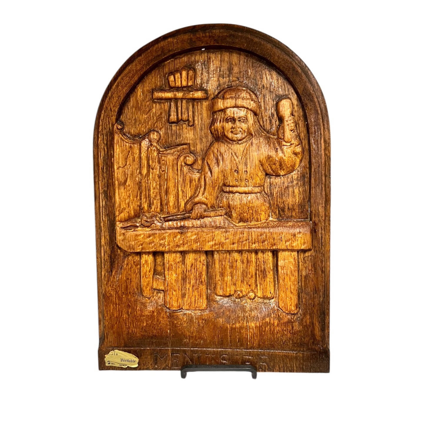 Wooden panel with carved scene of a person and objects on a white background