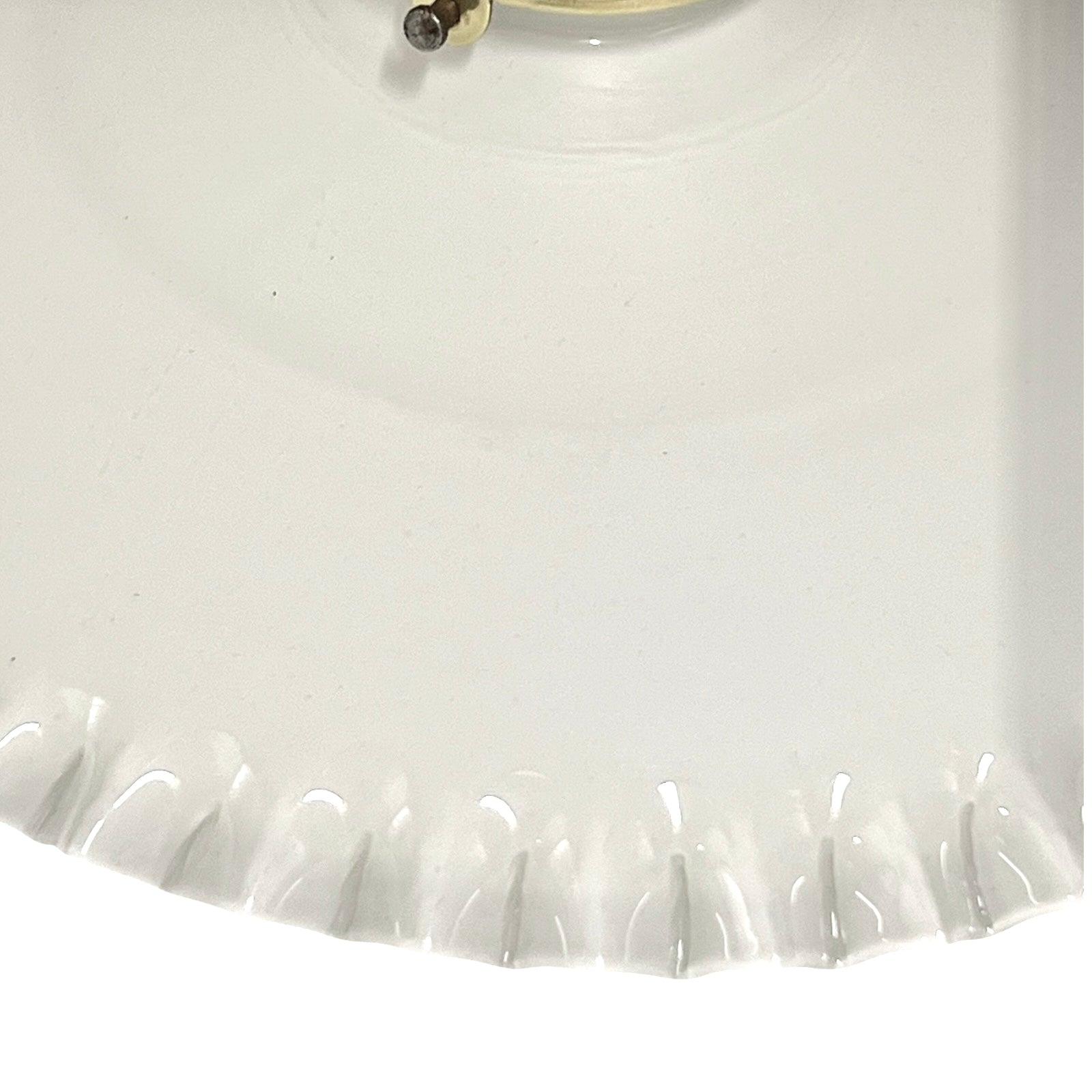 Close-up of a white glass lampshade with a scalloped edge.