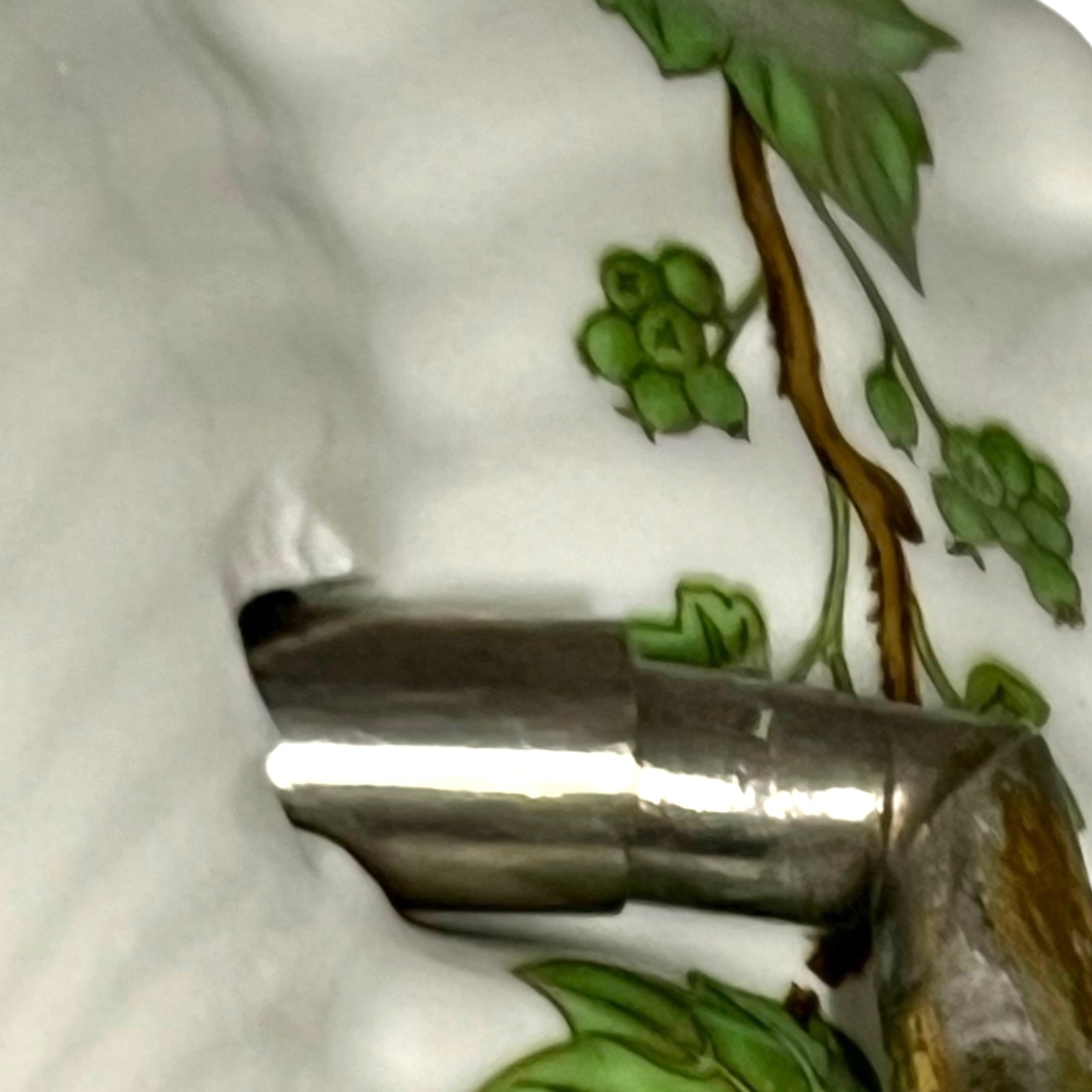 close up of towel hoop with leaf design on a white background