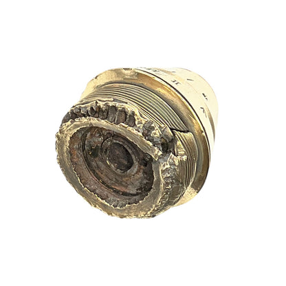 Close up of a polished British brass WW1 fuse or paperweight type 101 on a white background