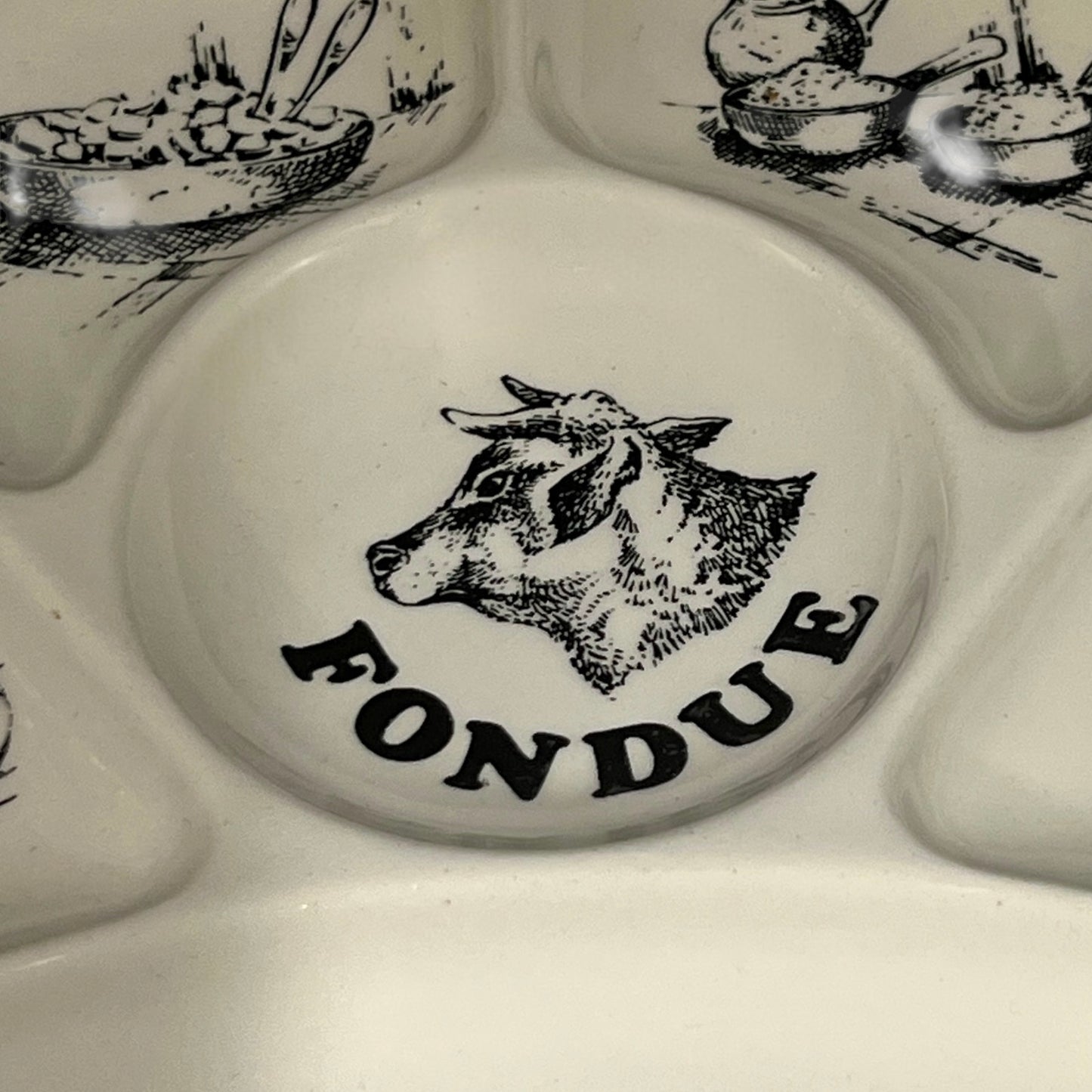 Fondue set with a cow illustration and 'FONDUE' text on a white background