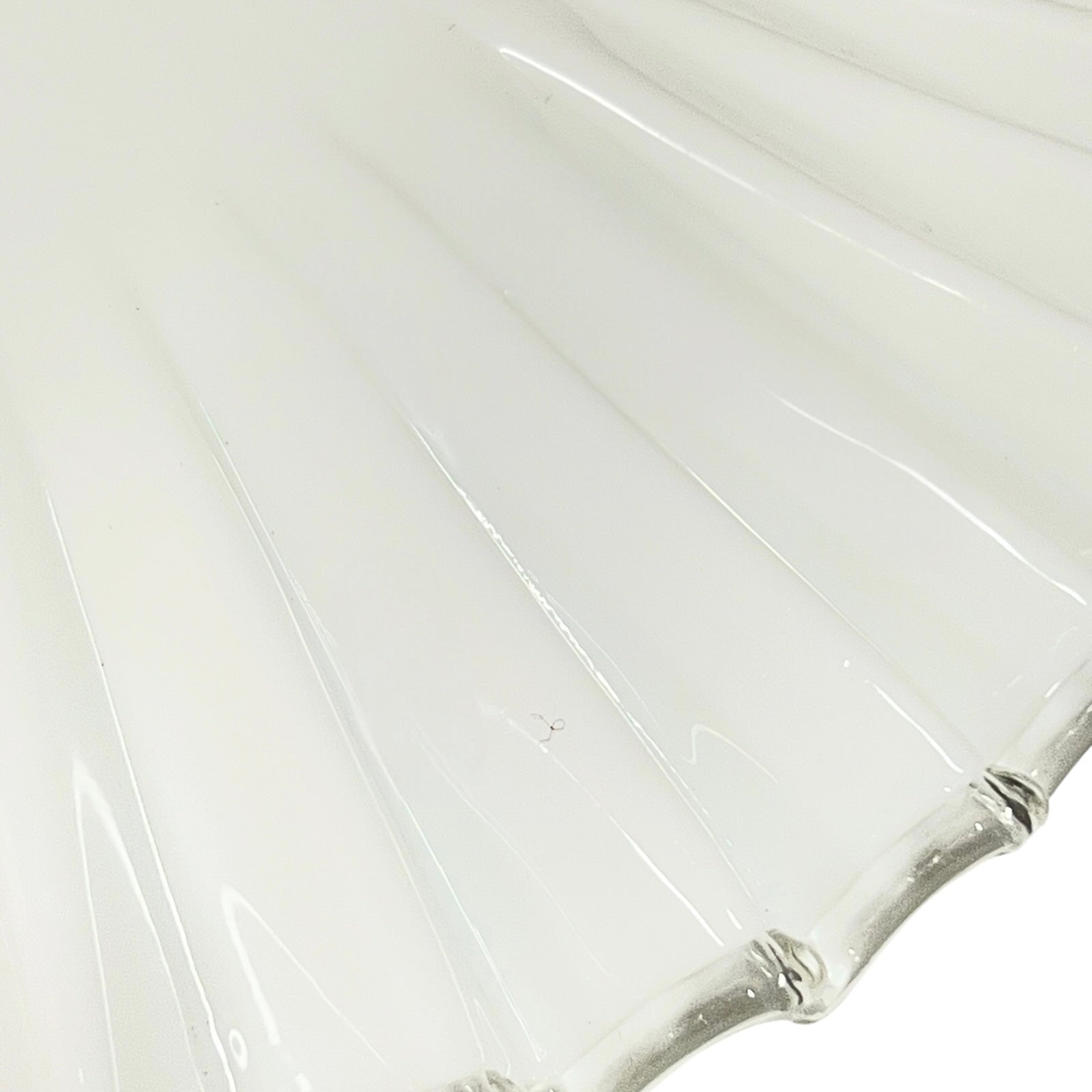 Close up of a White scalloped-edge glass lampshade with brass fitting on a white background, for a period living room styling or vintage home decor 