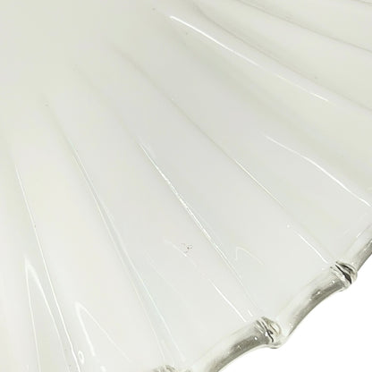 Close up of a White scalloped-edge glass lampshade with brass fitting on a white background, for a period living room styling or vintage home decor 