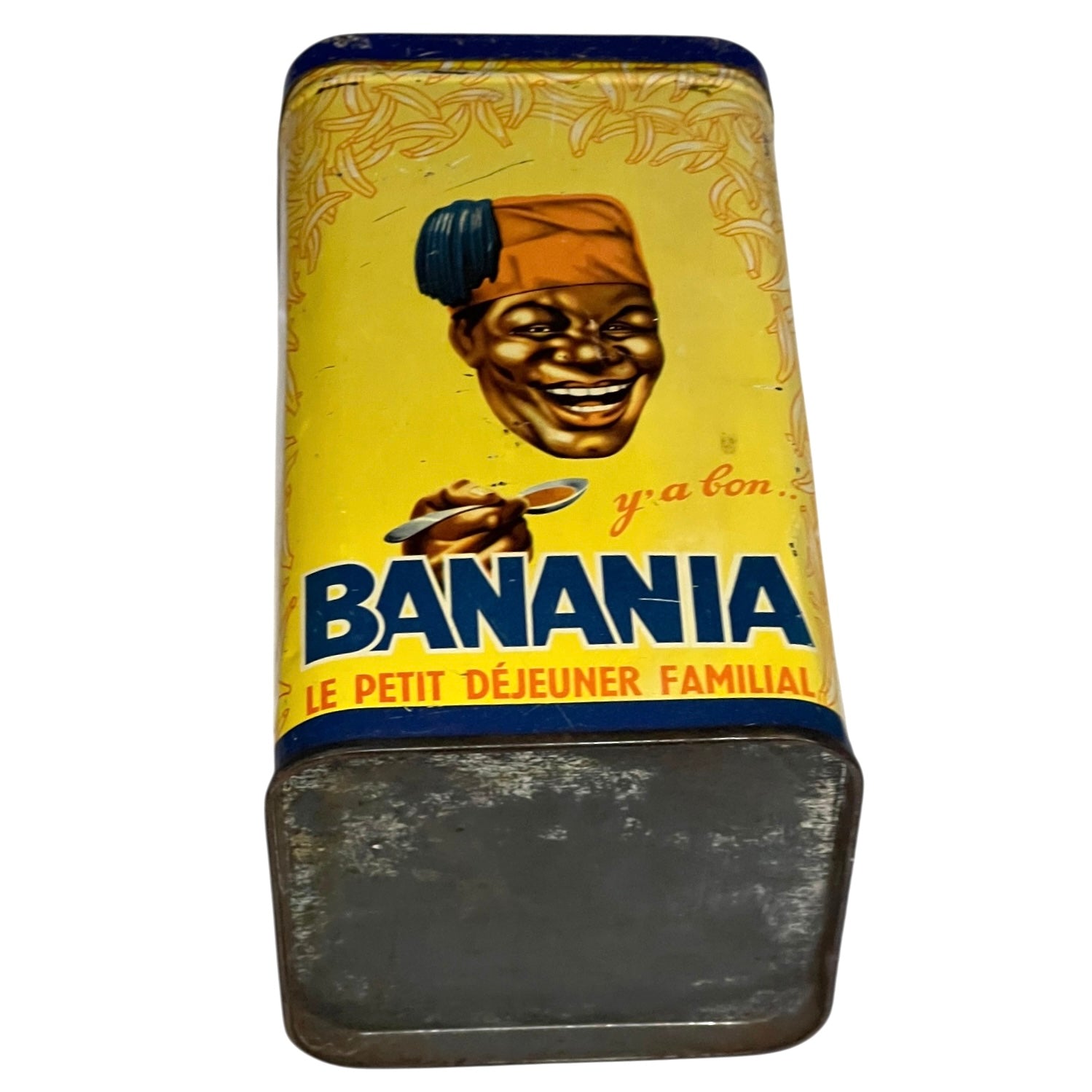 Vintage metal container with 'Banania' branding and a person holding a banana on a yellow background.