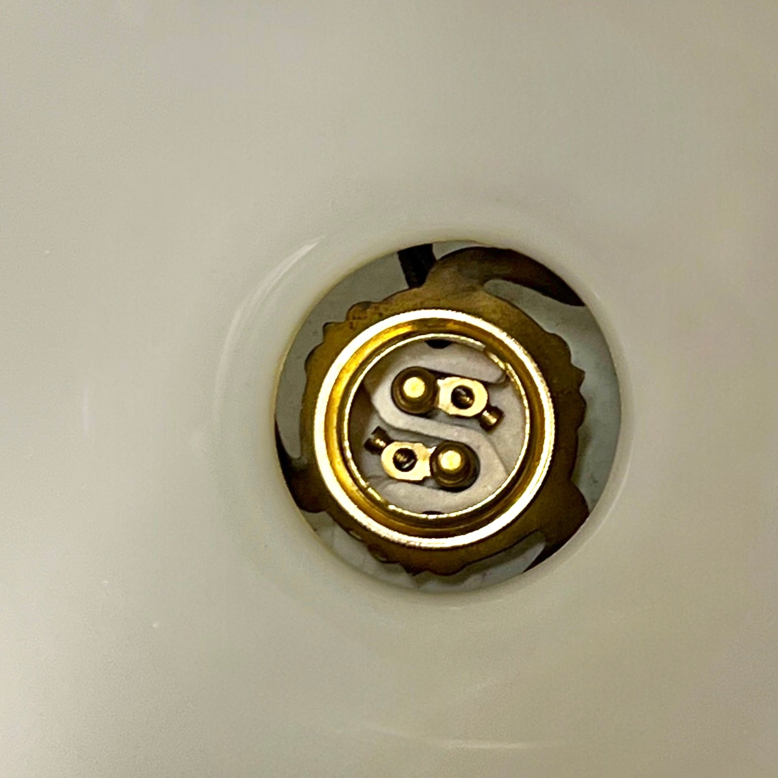 close up inside view of Vintage-style pendant light with a yellow glass shade and brass fitting on a white background