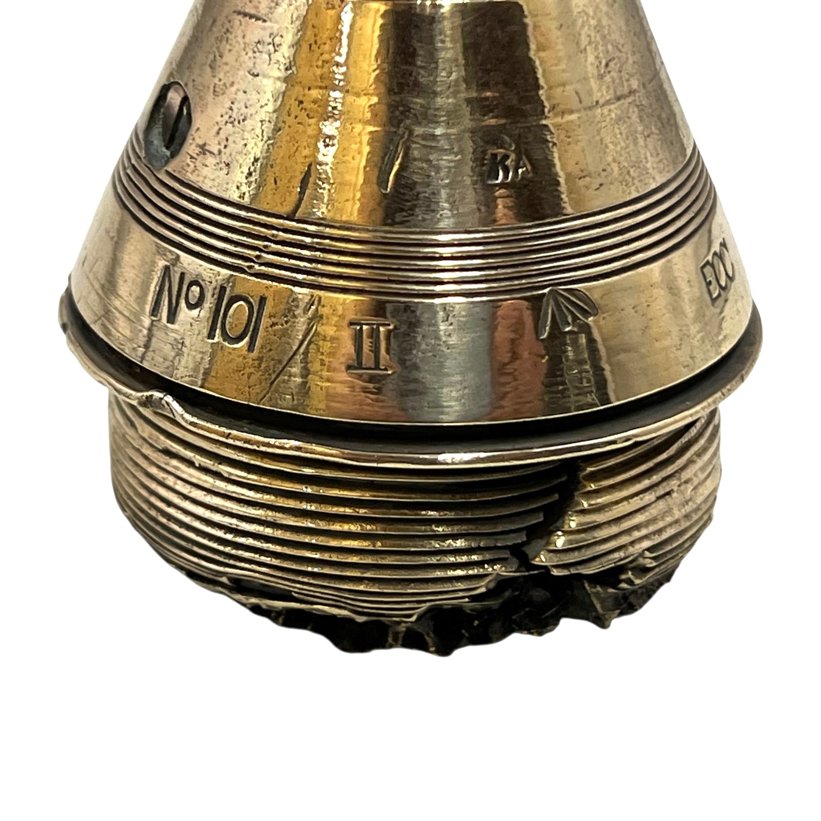 Close up of a polished British brass WW1 fuse or paperweight type 101 on a white background