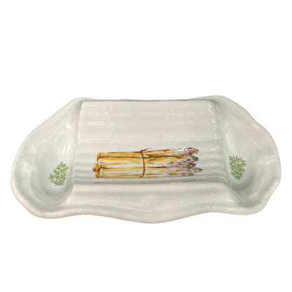 A white ceramic serving platter with a ribbed interior and asparagus illustrations near the corners, displayed on a plain background