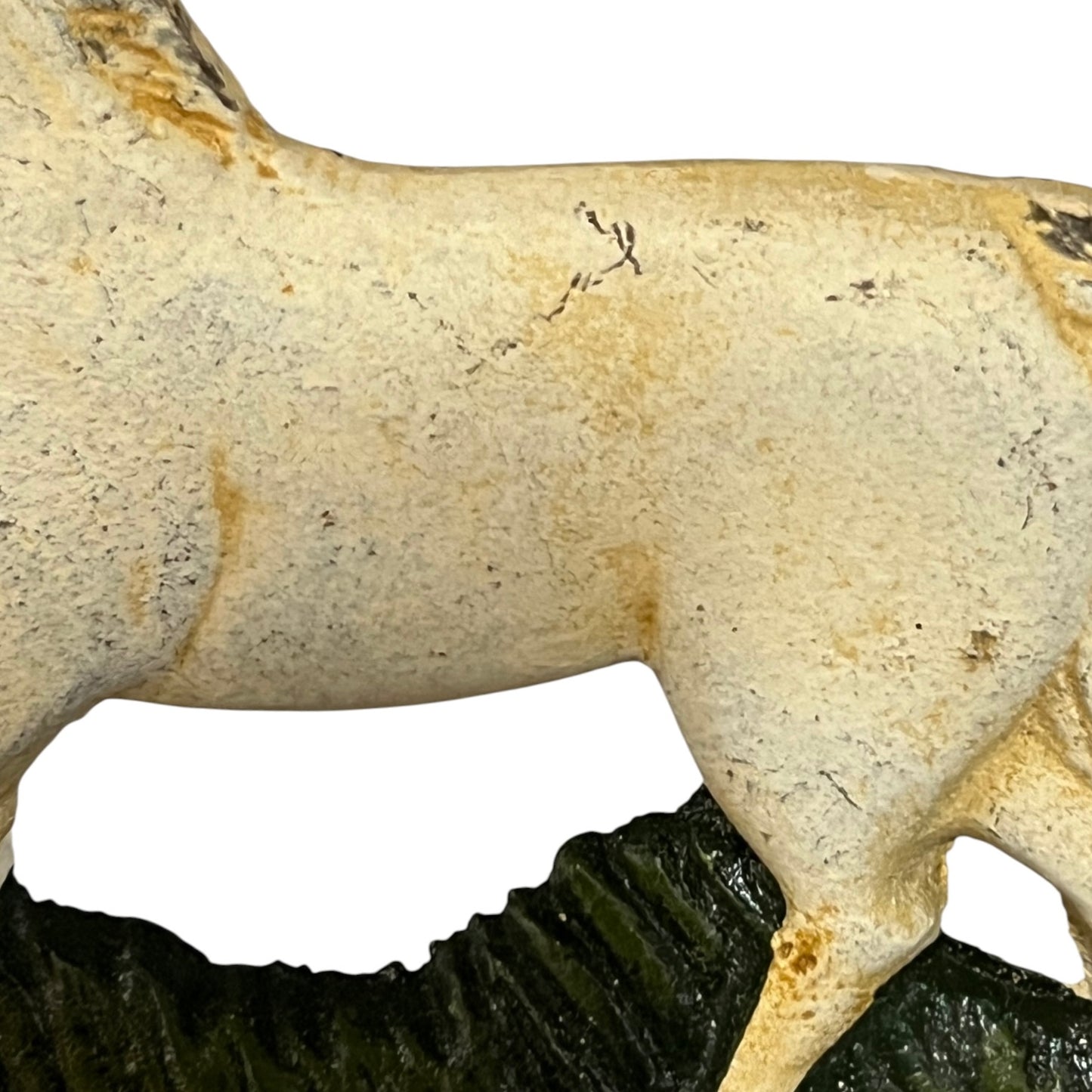A close-up of a horse figurine or sculpture showing the side profile, with a textured off-white body and a dark green base against a plain white background.