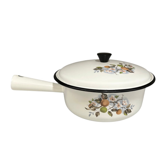 White enamel saucepan and lid with floral design on a white background