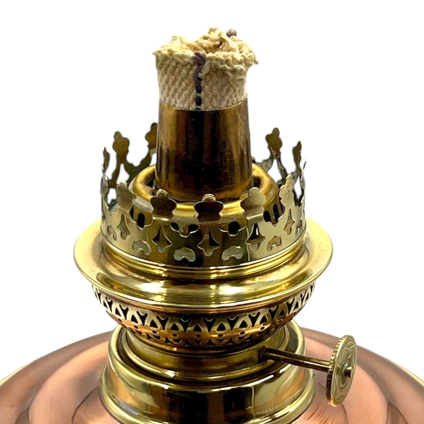 Brass oil lamp with intricate design on a white background