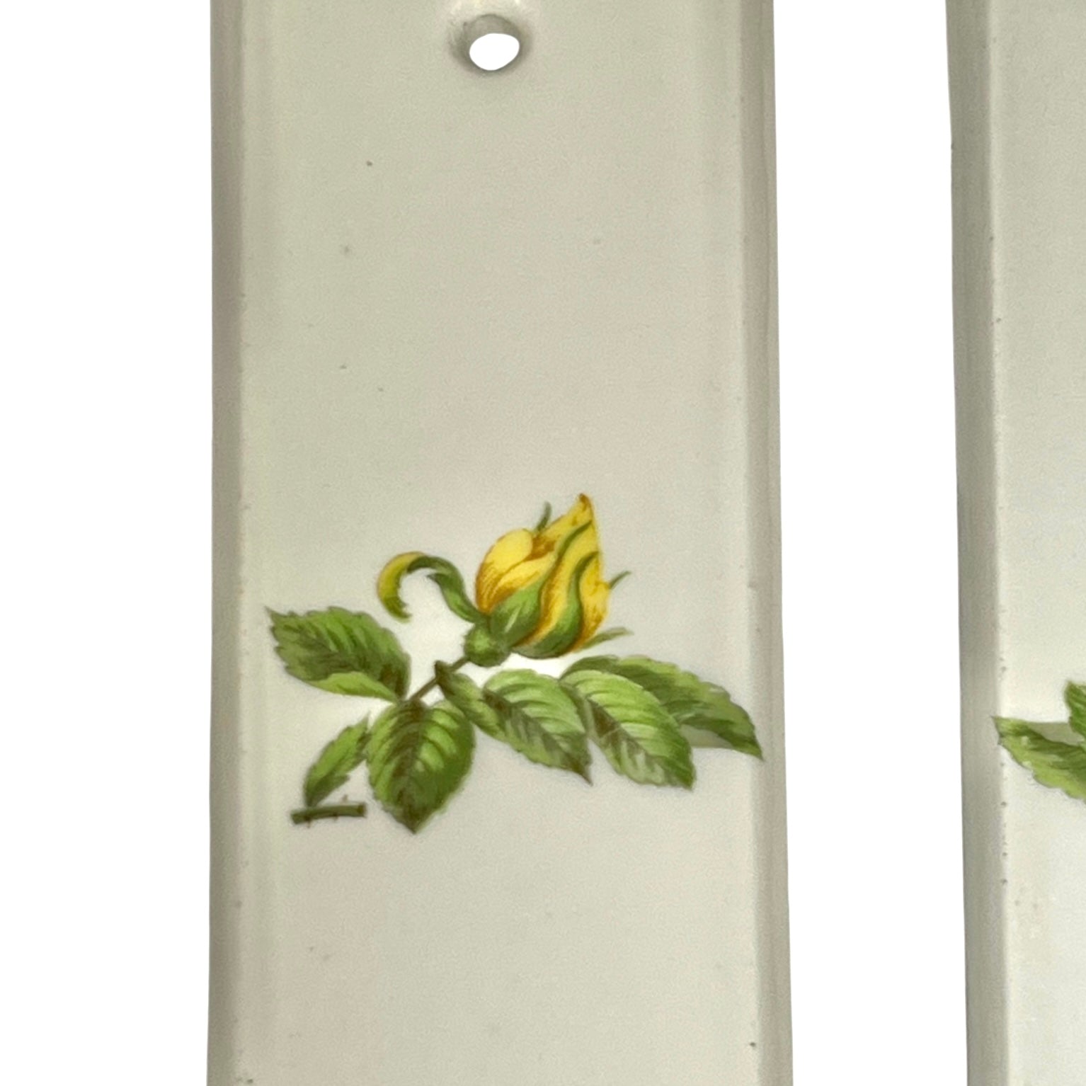 close up of door push plate with a yellow rose decoration on a white background